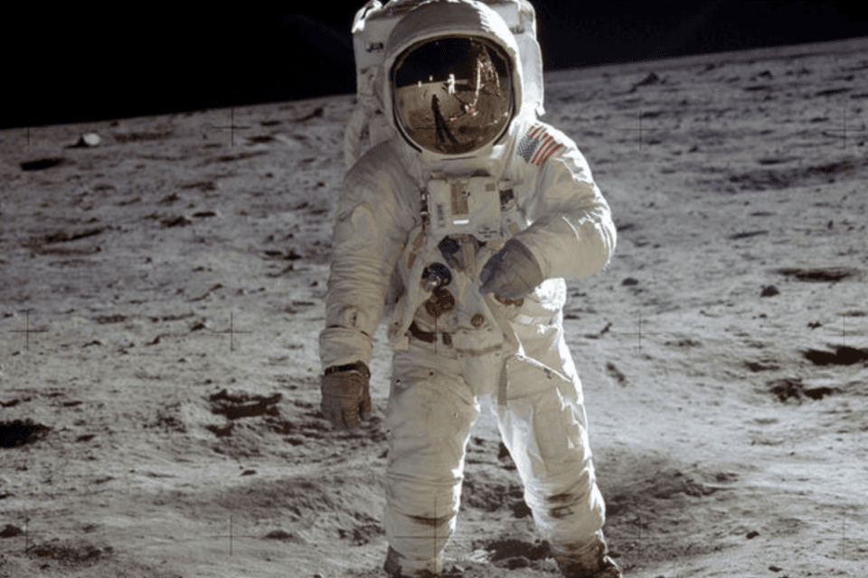 Buzz Aldrin traversing across the surface of the moon
