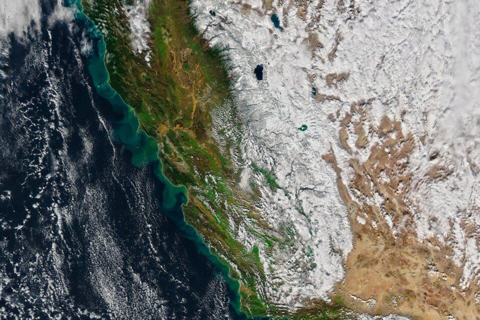 Sediment swirls along the coast of California