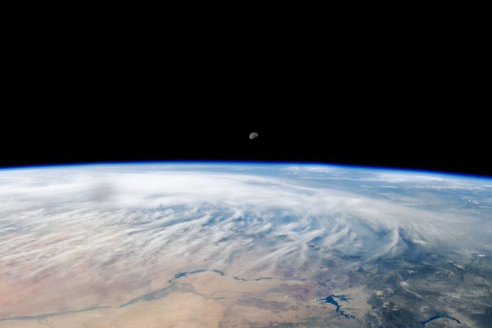The Moon peeks over Earth's horizon
