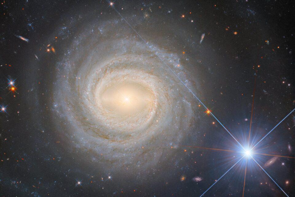 Luminous spiral galaxy and a blue giant star